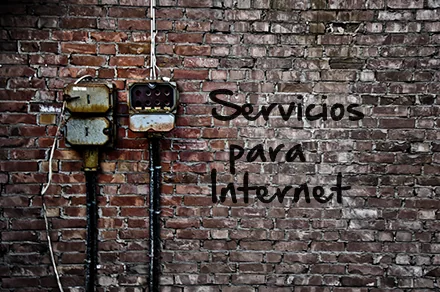 Muro de ladrillo con cuadros eléctricos antiguos y el rótulo pintado: Servicios para Internet.